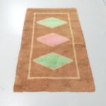 A mid-century hand tufted rug with geometric motifs. 150x93cm.