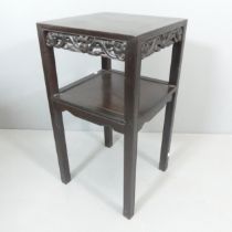 A Chinese hardwood two-tier lamp table, with applied carved decoration. 42x79cm.