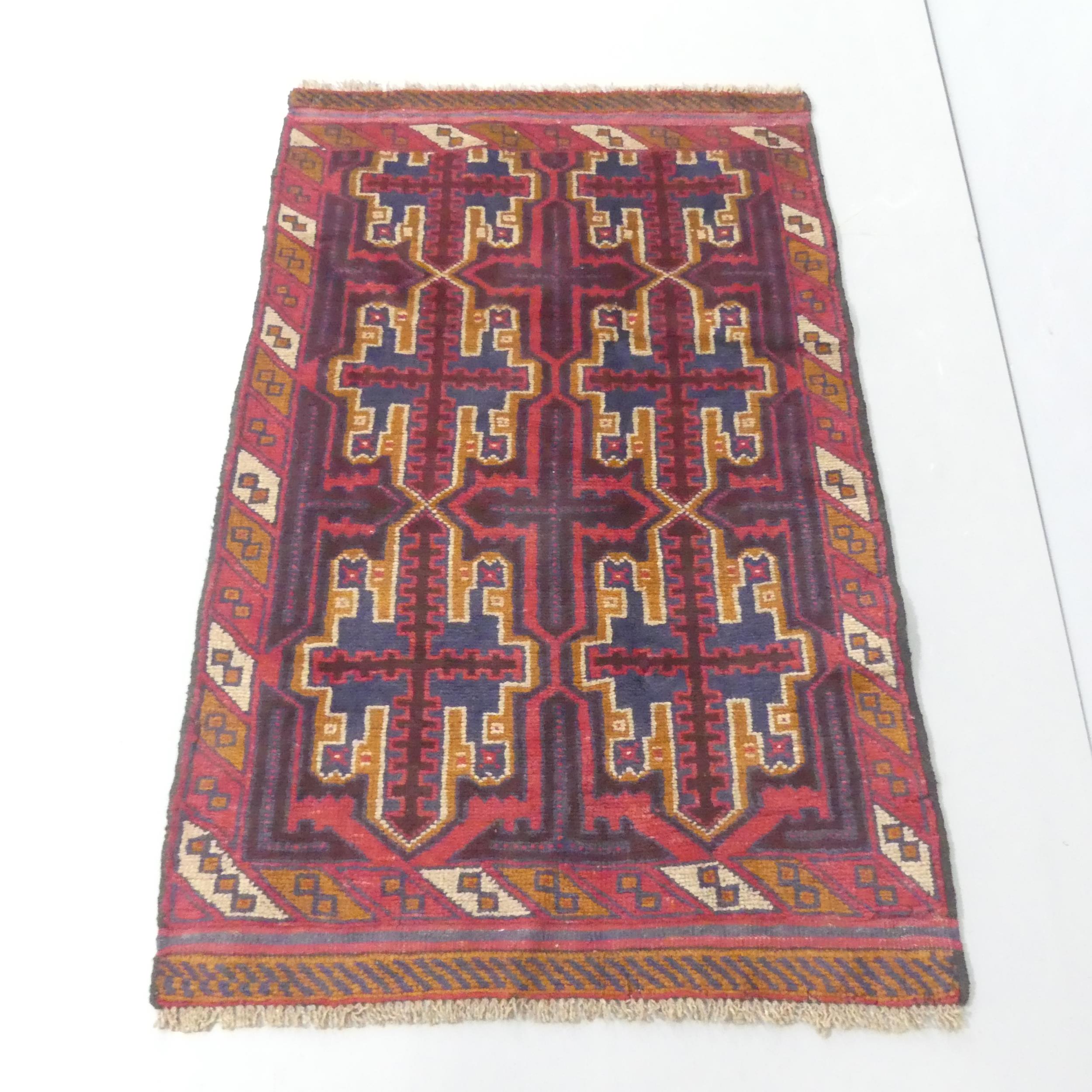 A red-ground Baluchi rug. 135x84cm.