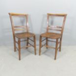 A pair of antique elm-seated chapel chairs.