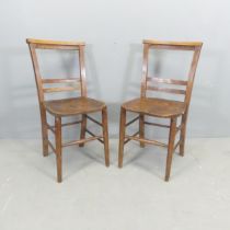 A pair of antique elm-seated chapel chairs.