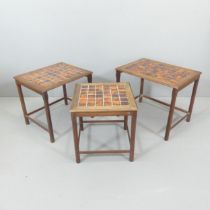 A mid-century teak nest of three tile-top occasional tables. Largest 58x47x41cm.
