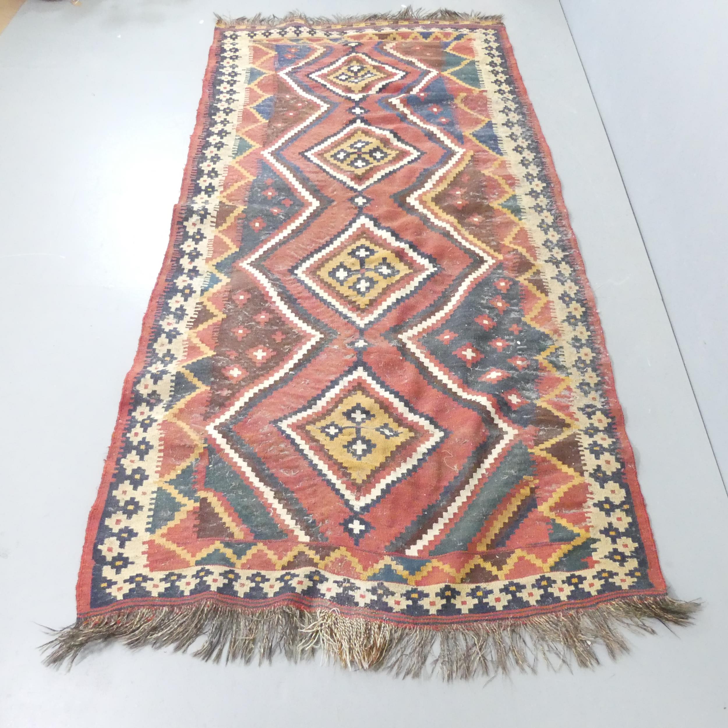A red and cream-ground Kilim carpet. 270x126cm. Some signs of moth damage. Would benefit from a