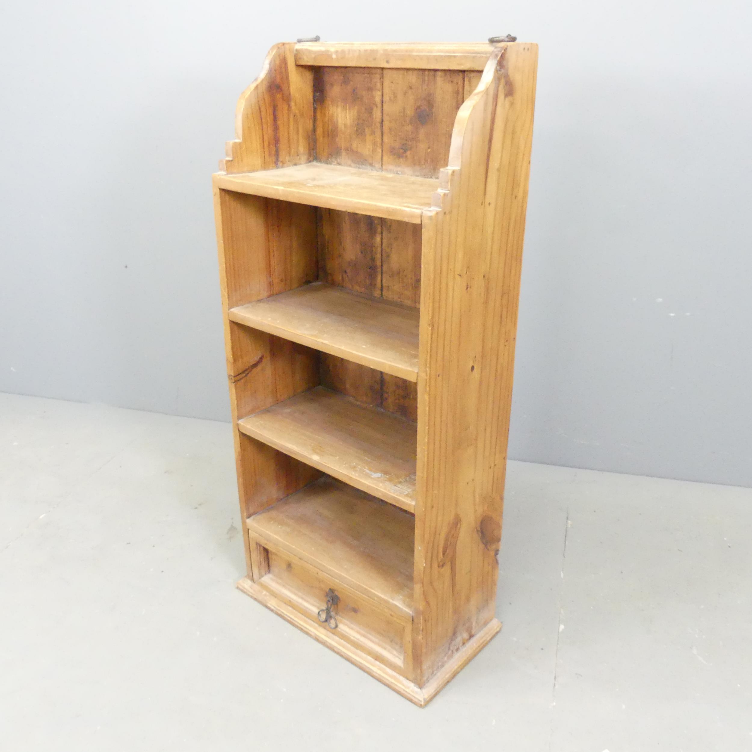 A modern pine open bookcase, with four fixed shelves and drawer under. 47x105x26cm.