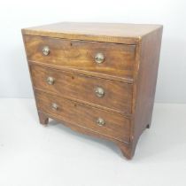 An Edwardian oak chest of three long drawers, with inlaid chequered banding, and raised on