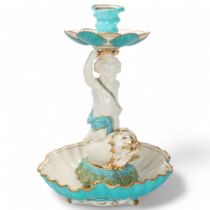 A 19th century ceramic table centre, supported by a cherub riding a gurgle fish, no factory marks,