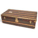 A Vintage French travelling trunk, brass wood and leather-bound with printed canvas panels, Damier