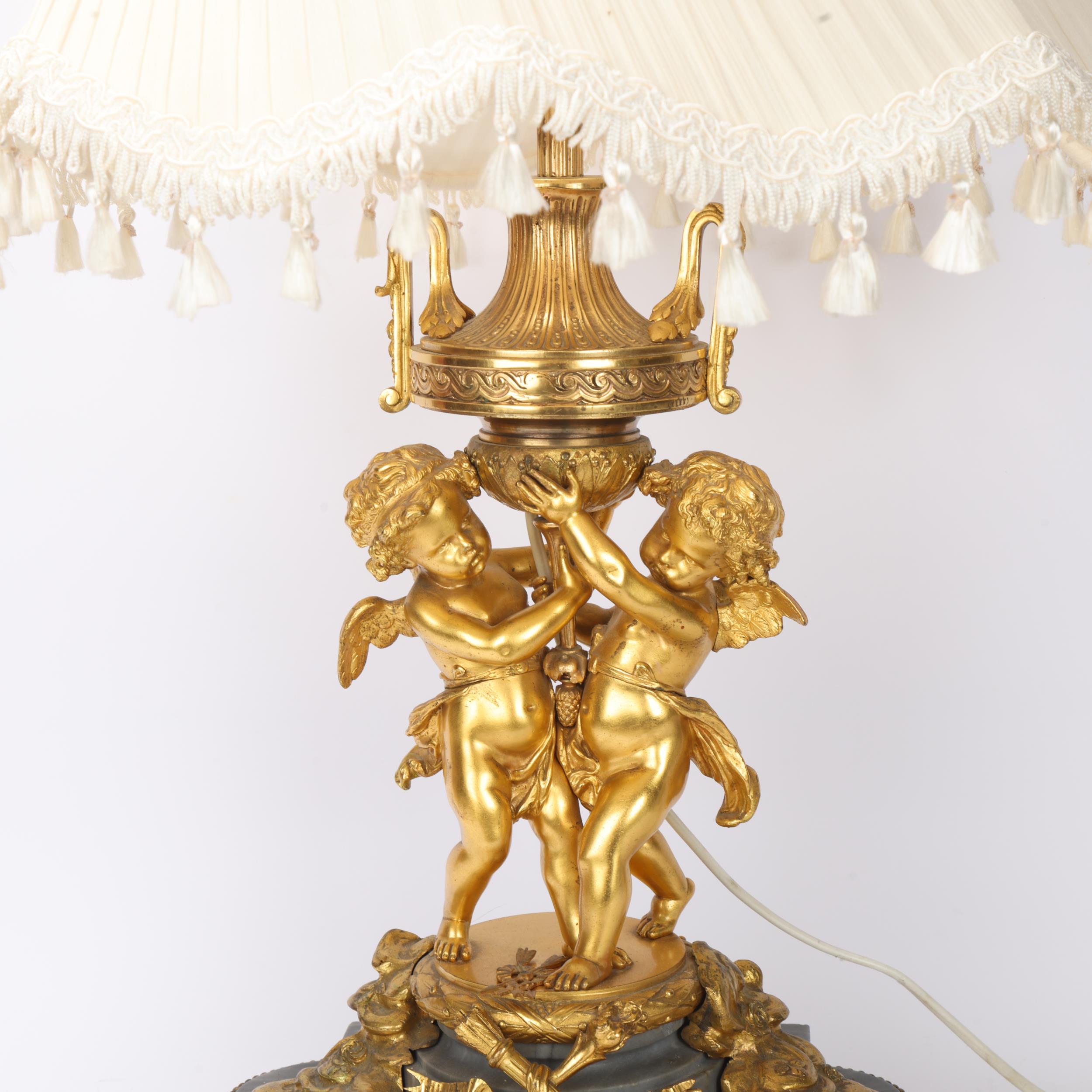An ornate French gilt-bronze table lamp, supported by 2 cherubs, probably late 19th century, on - Image 2 of 3