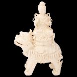 A Chinese blanc de chine porcelain figure of Buddha on a dog of fo, impressed seal and gourd mark to