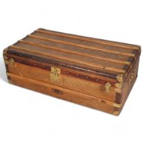 A Vintage French travelling trunk, brass wood and leather-bound with canvas panels, original label