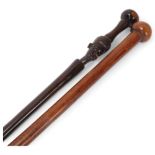 A Zulu lignum vitae ball end stick, length 93cm, and an African hardwood stick with carved head (2)