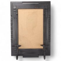 Attributed SARAJ GUHA, a hand wrought mild steel mirror frame, with two candle sconces, height 61cm,