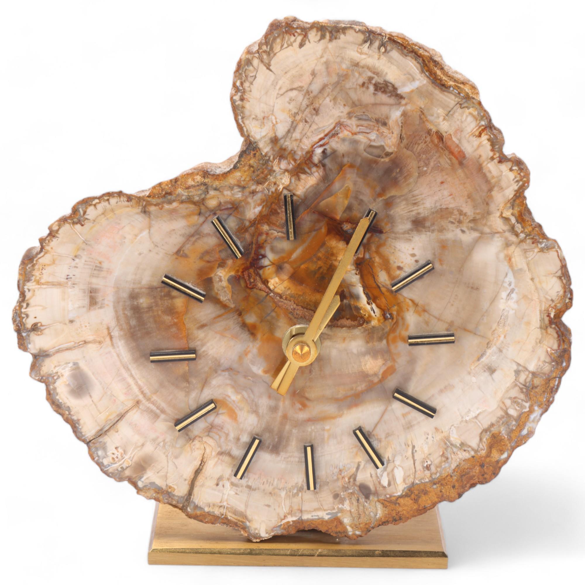 A mid 20th century quartz clock, with a fossilised wood face on brass stand, no makers mark,
