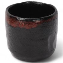A Japanese studio pottery tea-bowl, raku fired with impressed thumb mark and makers stamp, in