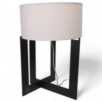 A stylish black painted table lamp, the X form base supporting a white shade, height 61cm Good