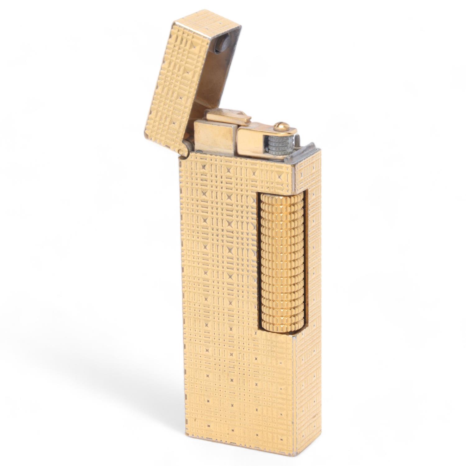 A vintage Dunhill Rollagas gold plated lighter, textured body, makers marks to base, length 6.3cm