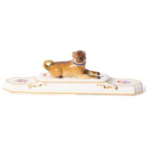 A 19th century porcelain Pug paperweight, on stepped plinth base, a gold and blue collar with gilded
