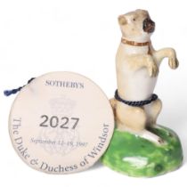 An early 19th century English porcelain figure of a begging Pug dog, with pale tan coat, black