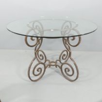 A mid-century French wrought iron dining table in the Hollywood Regency manner with circular glass