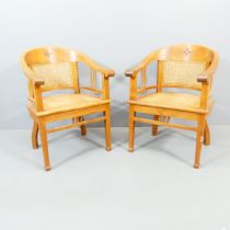 A pair of contemporary teak tub-chairs in the manner of Frank Hudson, with cane panelled backs and