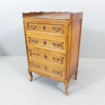 A decorative French Louis XV style cherrywood tray-top chest of four drawers, raised on cabriole