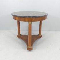 A French mahogany marble-topped Gueridon / centre table, raised on three turned legs with platform