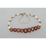 Edwardian gem set bracelet, set with nine amber coloured cushion cut stones (untested), in