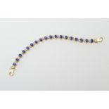Continental lapis lazuli line bracelet in 14ct gold, the cabochon stones in collet mounts, with