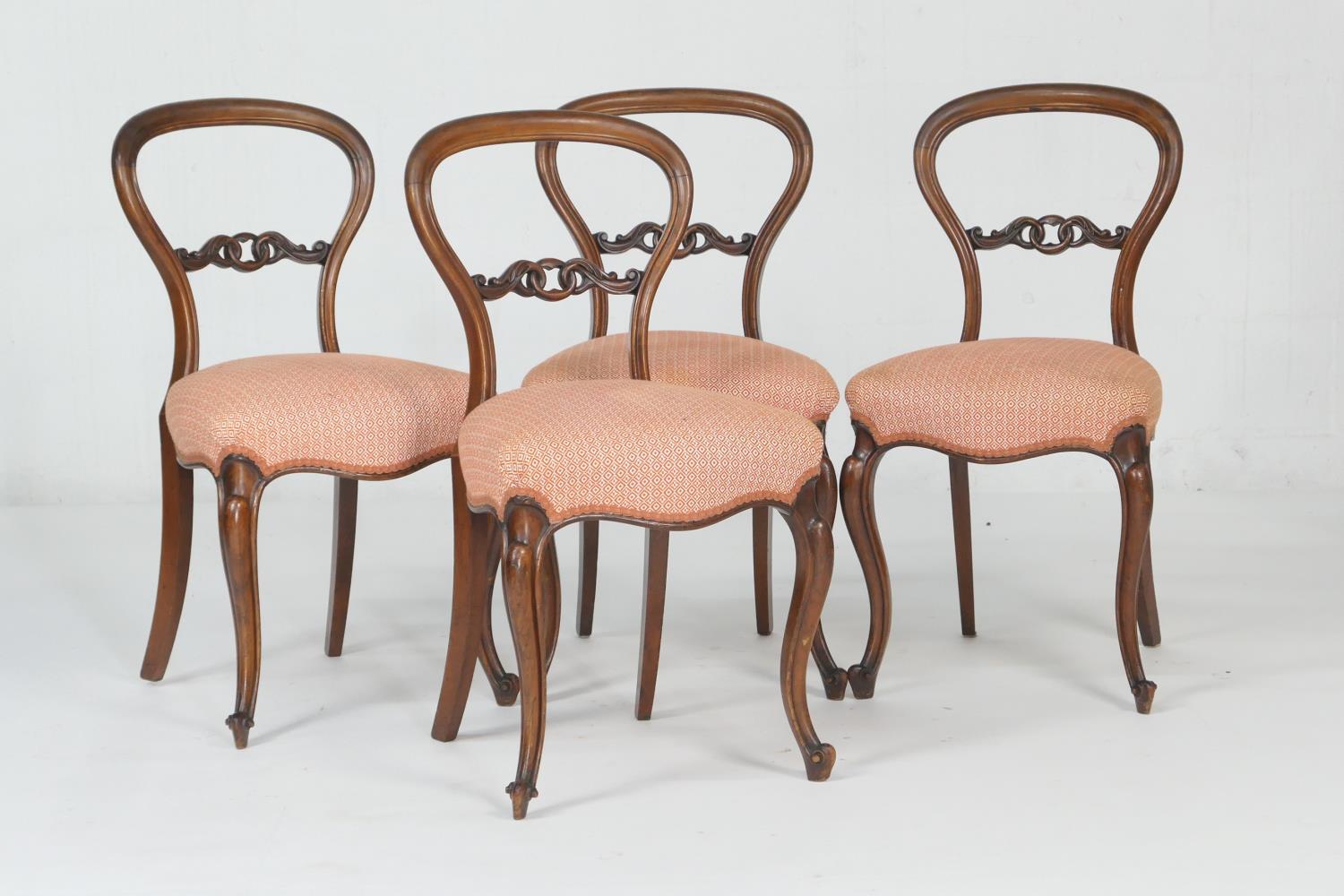 Set of four Victorian walnut balloon back dining chairs, circa 1870, with a carved centre bar,