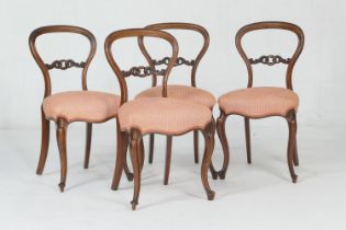 Set of four Victorian walnut balloon back dining chairs, circa 1870, with a carved centre bar,