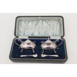 George V cased silver wet mustard pots, maker HW, Sheffield 1912, each with clear glass liner and