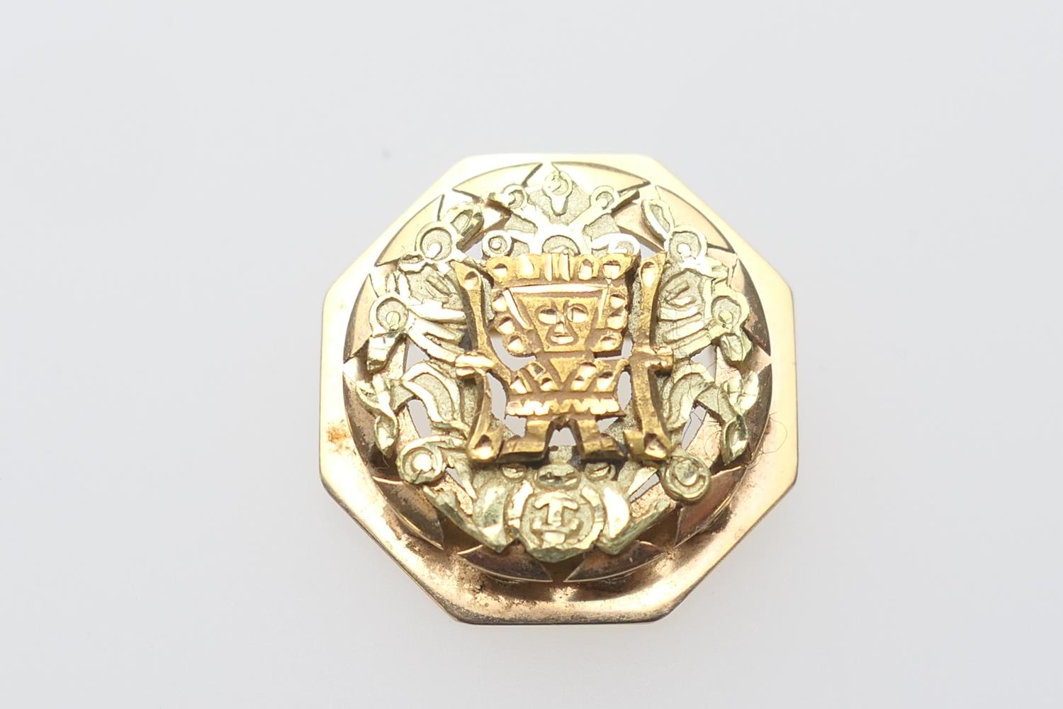 18ct gold octagonal brooch, centred with an Aztec style figure, 25mm diameter, weight approx. 12.