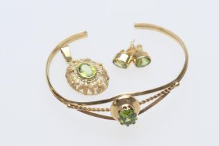 Peridot set bangle, oval cut stone in an openwork unmarked gold coloured bangle, also a pair of