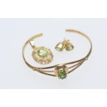 Peridot set bangle, oval cut stone in an openwork unmarked gold coloured bangle, also a pair of