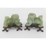Pair of Chinese carved celadon green jade Kylins, 20th Century, on carved wooden stands, 11.5cm x
