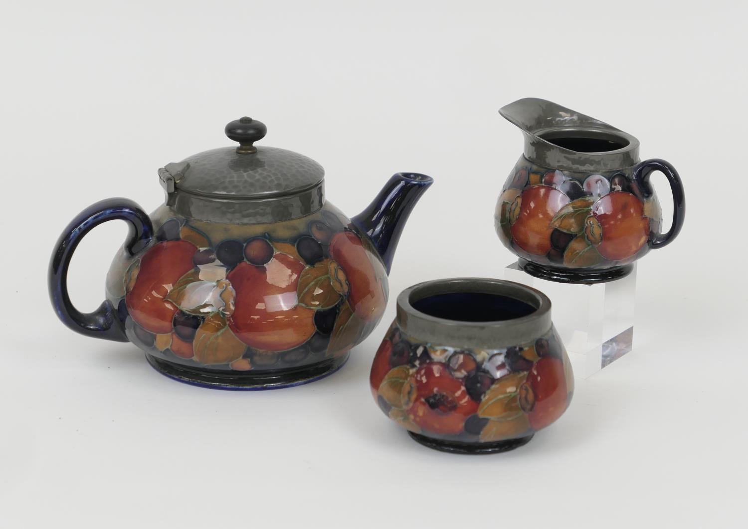 William Moorcroft Pomegranate three piece tea service, comprising teapot with hammered pewter mounts