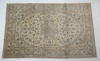 Kashan fawn ground woollen rug, the field dispersed with palmettes and foliage in light and dark