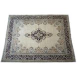 Kirman fawn ground woollen carpet, centred with a pink blue and pink foliate medallion, bordered