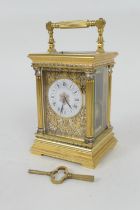 Brass repeating carriage clock, having a printed dial with Roman numerals, within brass fretted