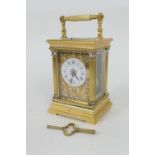 Brass repeating carriage clock, having a printed dial with Roman numerals, within brass fretted