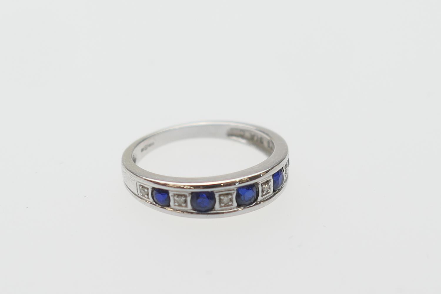 Synthetic sapphire and diamond half eternity ring, in 9ct white gold, the round cut stones channel