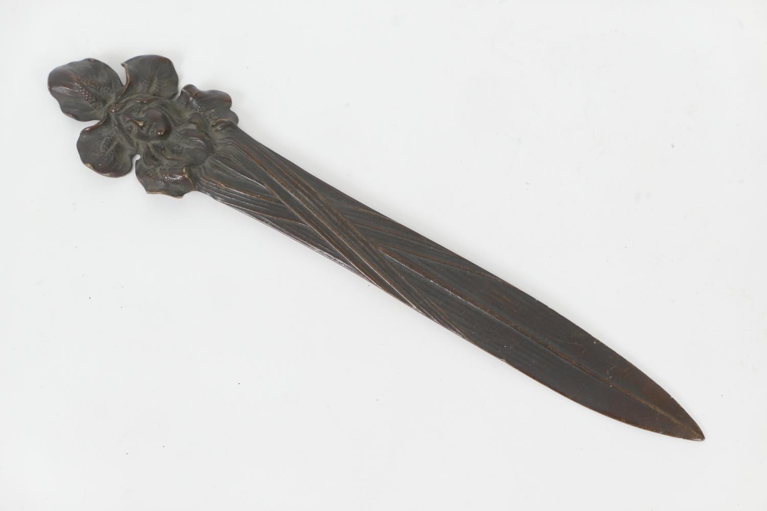 French Art Nouveau bronze paper knife, circa 1900, cast with the face of a girl centred within an