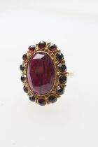 Late Victorian garnet cluster ring, centred with a faceted oval garnet of approx. 17mm x 12mm,