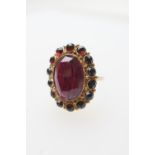 Late Victorian garnet cluster ring, centred with a faceted oval garnet of approx. 17mm x 12mm,