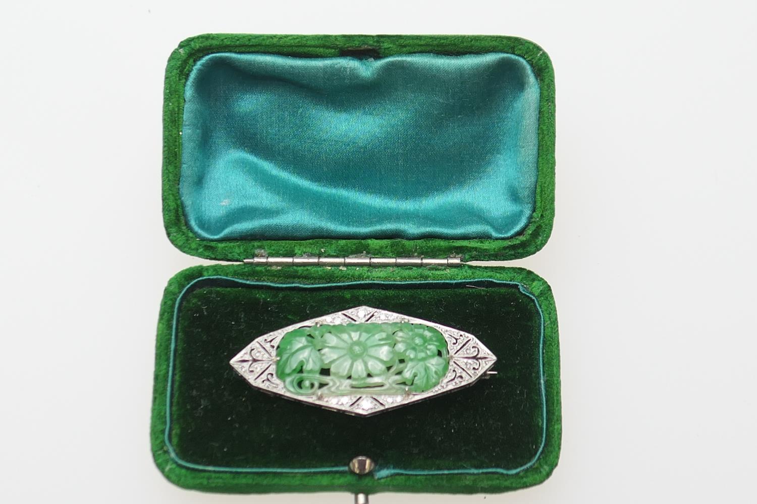 Art Deco carved jade and diamond brooch in 18ct gold and platinum, lozenge shape centred with a jade