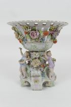 Plaue porcelain table centre, the central circular basket supported on a base encrusted with flowers