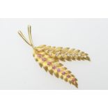 Yellow gold, diamond and ruby twin leaf brooch, set with seven small round cut diamonds and eight