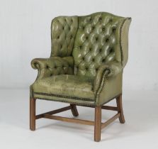 Deep buttoned green leather armchair in the Georgian style, raised on moulded square section legs,