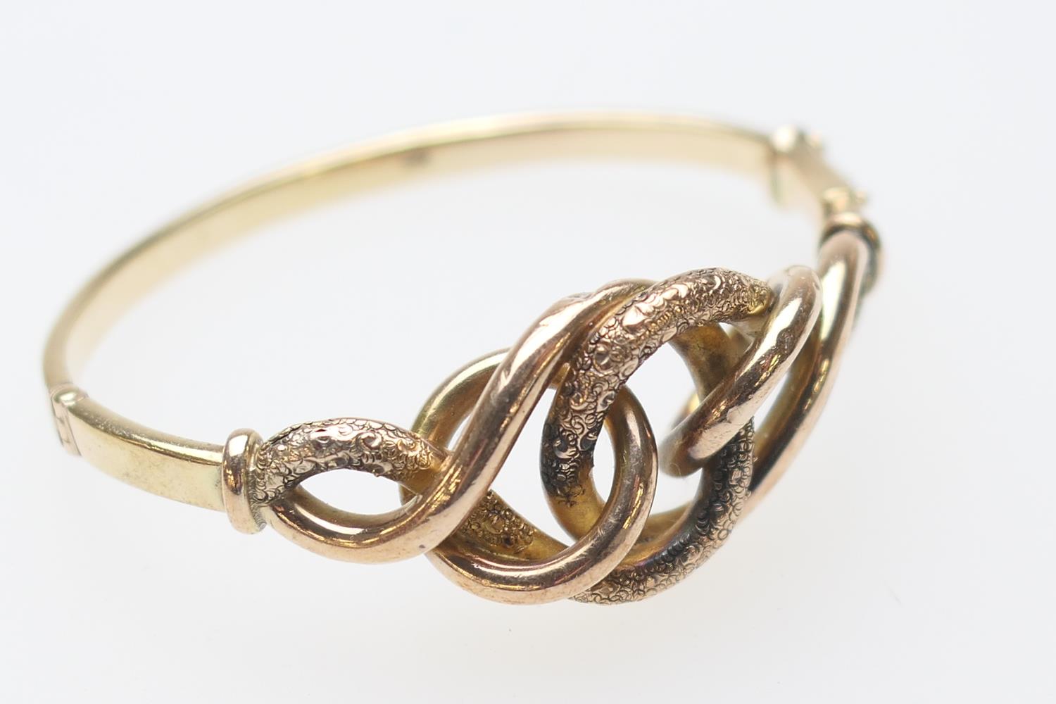 9ct gold hinged bangle, formed as an openwork knot, with a textured finish, cuff size 57mm, weight