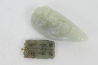 Chinese carved jade pendant, 55mm x 34mm; also a celadon jadeite pebble, carved with a happy Buddha,